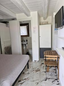a bedroom with a bed and a table and a bathroom at La Dolce Vita in Castelfidardo