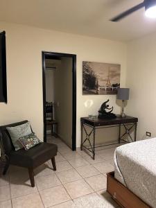 a bedroom with a bed and a chair and a desk at Casa Arboledas in Reynosa +2 photos