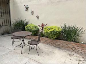 a table and chairs sitting next to a wall with plants at Casa Arboledas in Reynosa