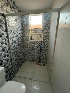 una doccia con una porta in vetro in un bagno di Casa de Praia Coqueiro - Luís Correia, Piauí a Luis Correia