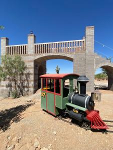 a small train on the tracks in front of a bridge at Tropical Mountain Valley Casita in Mesa