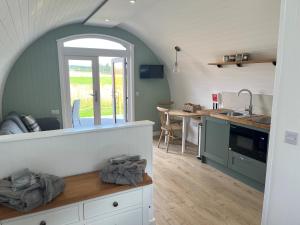 a kitchen with an arched window and a counter top at Barn Owl Pod - Speyside in Carron