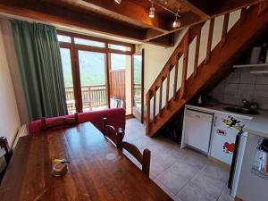 ein Wohnzimmer mit einem Holztisch und einer Küche in der Unterkunft Résidence Plein Soleil - Petit duplex 4 pers plein sud sur les hauteurs du village MAE-2803 in Montgenèvre