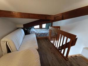 ein Wohnzimmer mit einem Sofa und einer Treppe in der Unterkunft Résidence Plein Soleil - Petit duplex 4 pers plein sud sur les hauteurs du village MAE-2803 in Montgenèvre