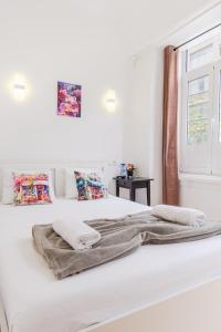 une chambre blanche avec deux lits et une fenêtre dans l'établissement Apartamento Sebastian, à Lisbonne