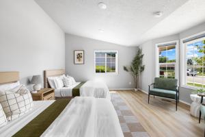 a bedroom with two beds and a couch and a chair at Stylish Renovation, Perfect for Families & Pets, Garage Parking, Sleeps 10 in Boise