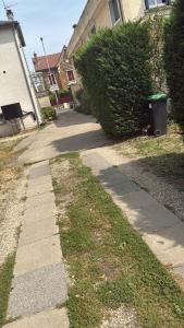 un marciapiede davanti a una casa con un cespuglio di COCON Cosy - Free Parking - City Center ad Arpajon