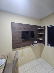 Una habitación con un televisor de pantalla plana en una pared. en Casa Recife Conforto 10, en Recife