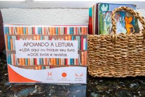 a basket of books sitting next to a pile of books at Hotel Express São Leopoldo in São Leopoldo