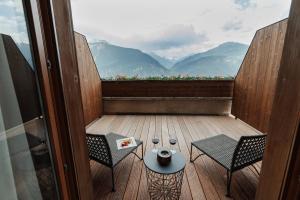 a balcony with two chairs and a table with a view at Boutique Hotel PANORAMA Crans-Montana in Crans-Montana