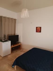a bedroom with a bed and a television and a chandelier at Casa IRI - plaja Corbu in Corbu +41 photos