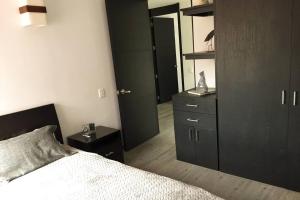 a bedroom with a bed and a dresser and a mirror at Acogedor Apartamento Loft en Club House en Cajicá in Cajicá +22 photos