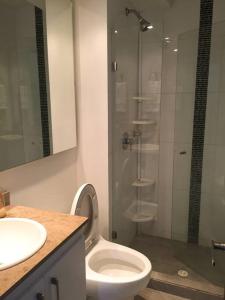 a bathroom with a toilet and a glass shower at Acogedor Apartamento Loft en Club House en Cajicá in Cajicá