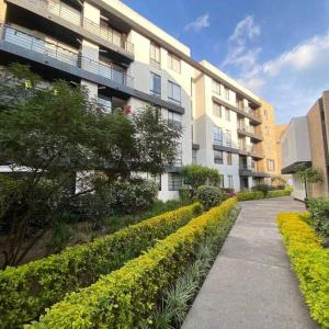 a sidewalk in front of a building with a row of bushes at Acogedor Apartamento Loft en Club House en Cajicá in Cajicá