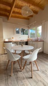 a kitchen with a white table and chairs at La casita in San Carlos de Bariloche +2 photos