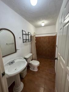 ein Badezimmer mit Waschbecken, Toilette und Spiegel in der Unterkunft Microhotel Ciudad del Carmen in Ciudad del Carmen