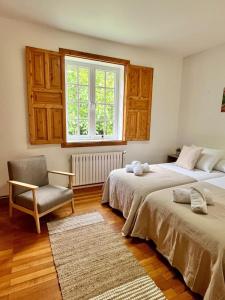 Un dormitorio con dos camas y una silla y una ventana. en Casa do Pepe, en Cedeira 47 fotos más