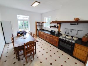 a kitchen with a table and chairs and a stove at Airtegal Casa do Pepe Cedeira in Cedeira
