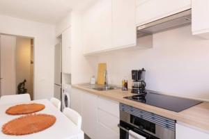 Una cocina con gabinetes blancos y una mesa con sillas. en Profithome- Casa Checha, en Candelaria 45 fotos más