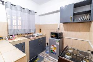 a small kitchen with a sink and a refrigerator at Taraji's Nest Homestays in Nanyuki