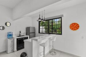 a white kitchen with a sink and a window at Romantic house Bucerías Two Turtles in Bucerías