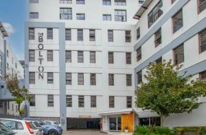 Un edificio blanco con coches aparcados delante. en Serene Studio - Steps away Rosebank Mall, en Johannesburgo
