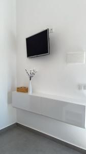 a white wall with a tv on a white wall at appartement 2 les oranges in Berkane