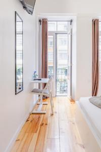 Cette chambre blanche dispose d'une table et d'une fenêtre. dans l'établissement Apartamento Sebastian, à Lisbonne