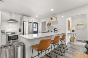 タンパにあるNEW SoHo Sanctuary - Gorgeous Apartment Steps to S Howard Ave with Fenced Yardのキッチン(カウンター、いくつかの椅子付)