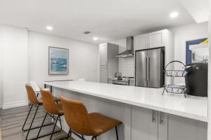 タンパにあるNEW SoHo Sanctuary - Gorgeous Apartment Steps to S Howard Ave with Fenced Yardのキッチン(白いキャビネット、カウンター、椅子付) +18枚の写真