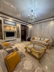 a living room with couches and a chandelier at Квартира в центре тбилиси in Tbilisi City