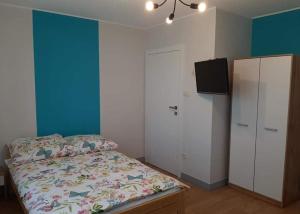 a bedroom with a bed and a cabinet and a tv at Dom na wzgórzu in Gołuchów