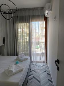 a bedroom with two beds and a large window at Olga Luxury Apartment in Paralia Katerinis