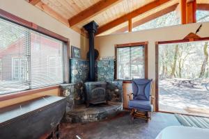 a living room with a wood stove and a chair at Hawkins Bar River Home in Hawkins Bar