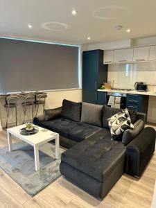 ノッティンガムにあるModern 2BR Central Apartment Sleeps 7 Walk to Shops & Arenaのソファとテーブルのあるリビングルーム
