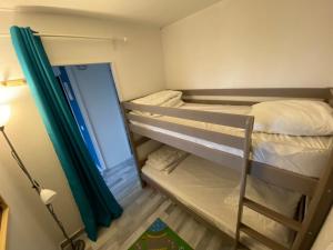 a small room with two bunk beds and a lamp at Havre de paix en bord de mer in Houlgate