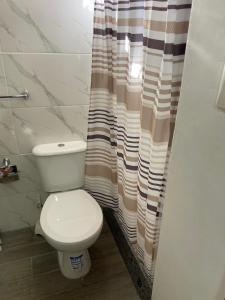 a bathroom with a toilet and a shower curtain at Moon Apart-hotel in Florida