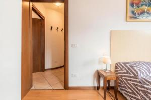 a bedroom with a mirror and a bed and a table at la terrazza del borgo con parcheggio in Malcesine