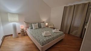 a bedroom with a bed with two towels on it at Casa Théméo - Centro città Verbania Intra in Verbania
