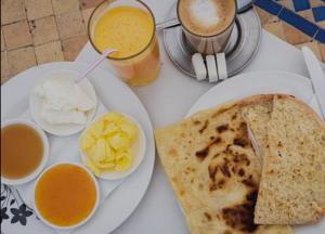 a white plate of food with eggs and bread and drinks at Riad la madriguera de Tetuan in Tétouan