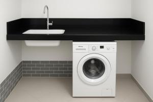 a kitchen with a sink and a washing machine at Villa Malkia's in Enaboishu