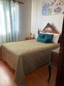 a bedroom with a large bed with blue pillows at Casa Vista Mar in Porto Martins