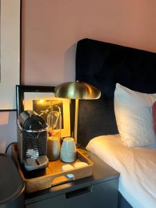 a bed with a table with a lamp on a night stand at Sunny apartment close to the sea in Oslo