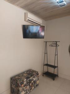 Una habitación con un televisor de pantalla plana en la pared. en Chalé na lata, en Pirenópolis
