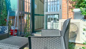 a patio with two chairs and a table at App 7 Modern apartment with private garden in Monza