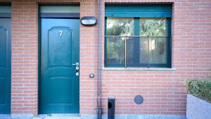 a blue door on the side of a brick building at App 7 Modern apartment with private garden in Monza