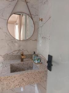 un baño con lavabo y espejo en Chalé na lata, en Pirenópolis 10 fotos más