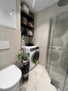 a bathroom with a washing machine and a shower at Sunny apartment close to the sea in Oslo +23 photos