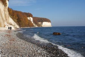 a couple of people walking along a rocky beach at Ferienwohnung Stein in Sassnitz +34 photos