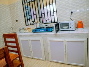 a kitchen with a microwave and a toaster oven on a counter at Nungwi Modern Apartment 2 in Kinyasini